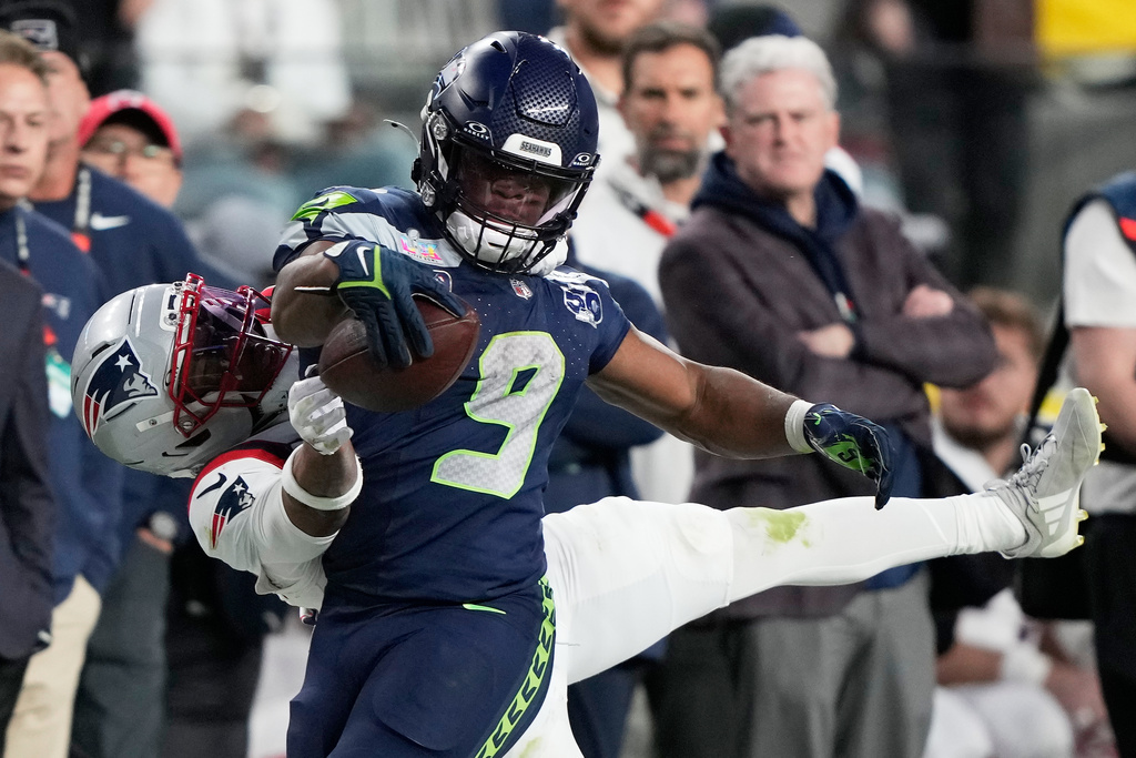 Seattle Seahawks running back Kenneth Walker III (9) runs against New England Patriots cornerback Marcus Jones during the second half of the NFL Super Bowl 60 football game, Sunday, Feb. 8, 2026, in Santa Clara, Calif. (AP Photo/Doug Benc)