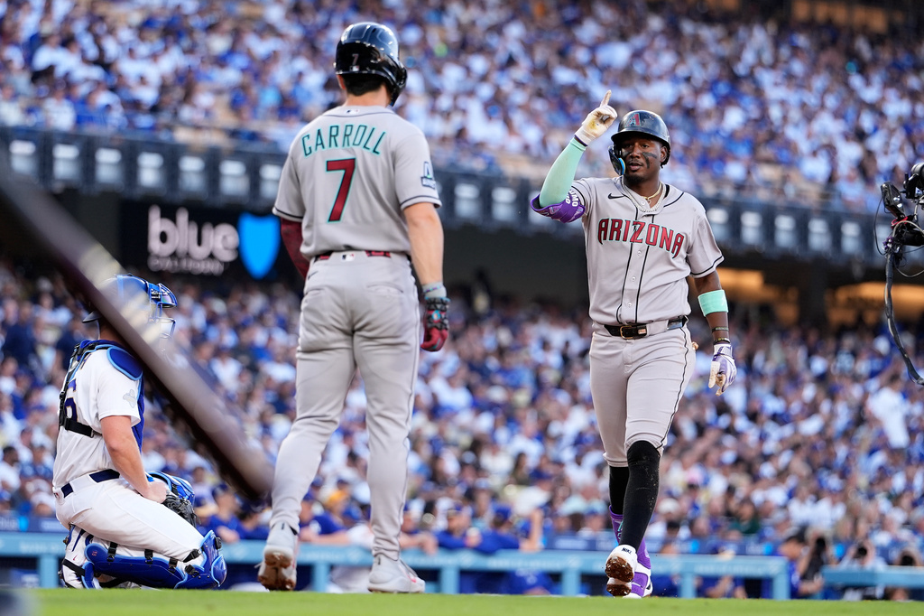 Arizona Diamondbacks' Geraldo Perdomo, right, celebrates after hitting a two-run home run that also scored Corbin Carroll (7) during the fourth inning of an opening-day baseball game against the Los Angeles Dodgers Thursday, March 26, 2026, in Los Angeles. (AP Photo/Mark J. Terrill)