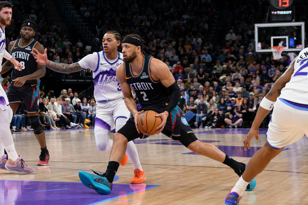 Detroit Pistons guard Cade Cunningham (2) drives to the basket past the defense of Utah Jazz guard Keyonte George, center rear, during the first half of an NBA basketball game, Friday, Dec. 26, 2025, in Salt Lake City. (AP Photo/Tyler Tate)