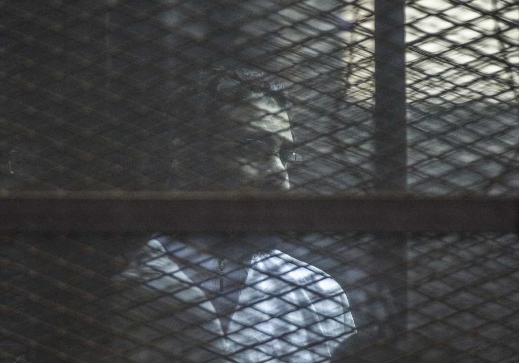 Prominent Egyptian activist Alaa Abd el-Fattah stands in a cage during a verdict hearing for 21 people over an unauthorized street protest in 2013, in a courtroom in Cairo, Egypt, on Feb. 23, 2015. (AP Photo)