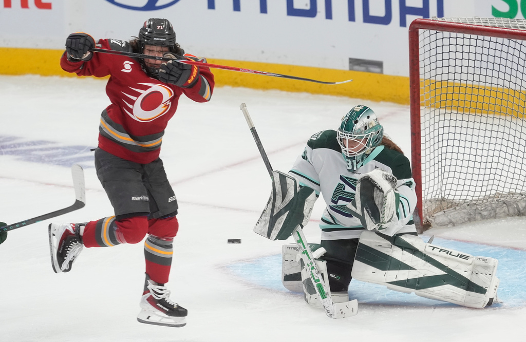 Ottawa Charge's Fanuza Kadirova, left, jumps to screen Boston Fleet goalie Aerin Frankel, right, during third-period PWHL hockey playoff action in Ottawa, Ontario, Friday, May 8, 2026. (Adrian Wyld/The Canadian Press via AP)