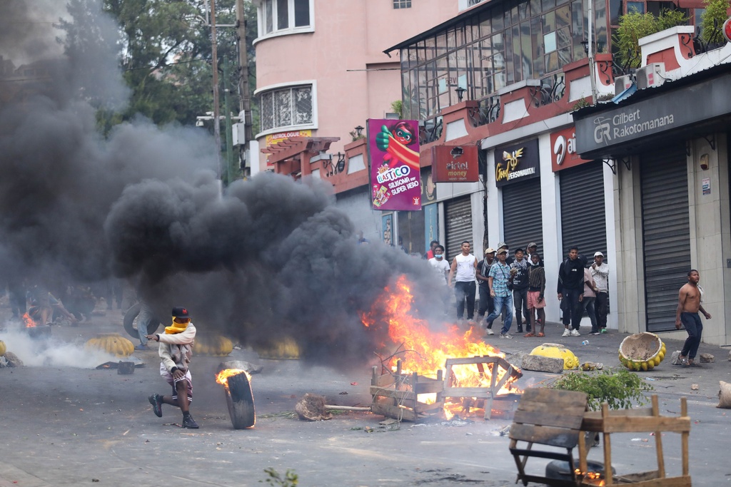 Demonstrators protesting against chronic electricity and water cuts confront riot police in Antananarivo, Madagascar, Tuesday, Sept. 30, 2025. (AP Photo/Mamyrael)