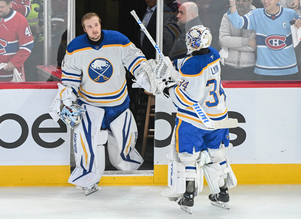 Buffalo Sabres goaltender Alex Lyon (34) touches gloves with fellow goalie Ukko-Pekka Luukkonen, left, after being pulled during the first period of Game 6 in a second-round NHL hockey Stanley Cup playoff series against the Montreal Canadiens in Montreal, Saturday, May 16, 2026. (Graham Hughes/The Canadian Press via AP)