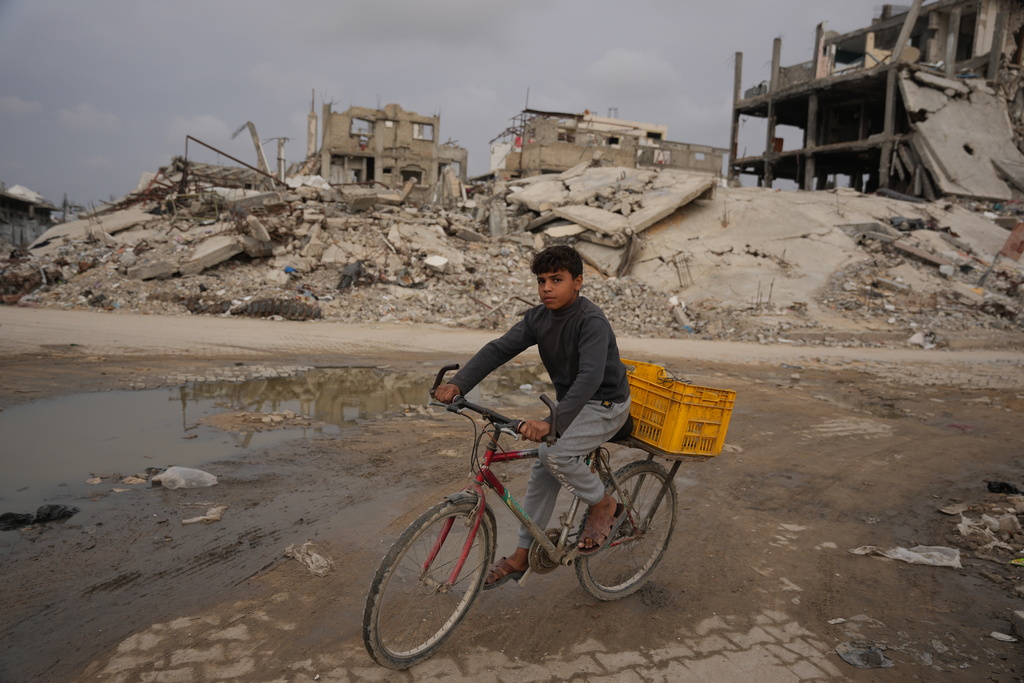 A Palestinian child rides his bicycle amidst the destruction in the Jabaliya refugee camp, northern Gaza Strip, Saturday, Dec. 6, 2025. (AP Photo/Abdel Kareem Hana)