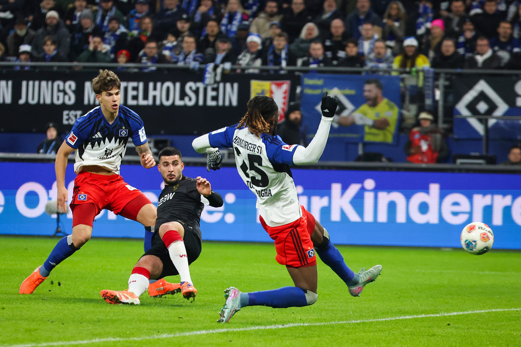 Stuttgart's Deniz Undav, center, scores their side's first goal of the game against Hamburger's Mario Vuskovic, left, and Jordan Torunarigha during the German Bundesliga soccer match between Hamburger SV and VfB Stuttgart in Hamburg, Germany, Sunday, Nov. 30, 2025. (Christian Charisius/dpa via AP)