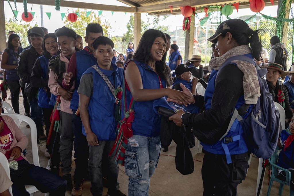 Teenagers and young adults receive an Indigenous guard vest and a folding chair at the end of the graduation ceremony on July 18, 2025, in Manuelico village, Caldono, Colombia. (AP Photo/Nadège Mazars)