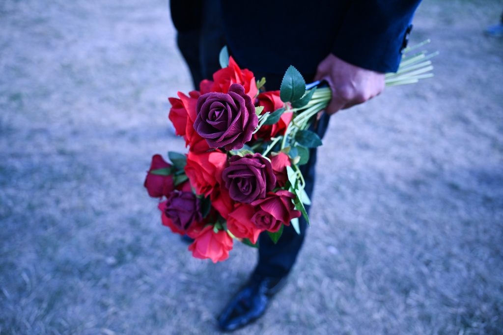 A groom holds a bouquet of flowers as he waits to take part in a mass wedding ceremony in an inflatable chapel in Amsterdam, Netherlands, Thursday, Aug. 6, 2026, as part of Pride events celebrating 25 years since the Netherlands became the first country in the world to legalize same-sex marriage. (AP Photo/Mouneb Taim)