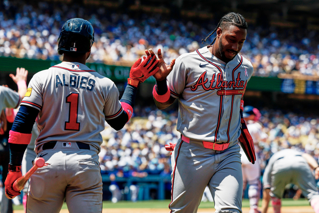 Atlanta Braves' Jorge Mateo, right, is greeted by Ozzie Albies (1) on a a two-run double by Atlanta Braves' Mauricio Dubon during the second inning of a baseball game against the Los Angeles Dodgers, Sunday, May 10, 2026, in Los Angeles. (AP Photo/Caroline Brehman)