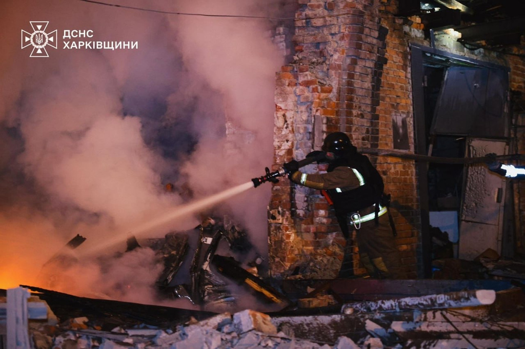 In this photo provided by the Ukrainian Emergency Services on Tuesday, Oct. 14, 2025, a rescue worker puts out a fire of a hospital damaged by a Russian strike in Kharkiv, Ukraine. (Ukrainian Emergency Service via AP)