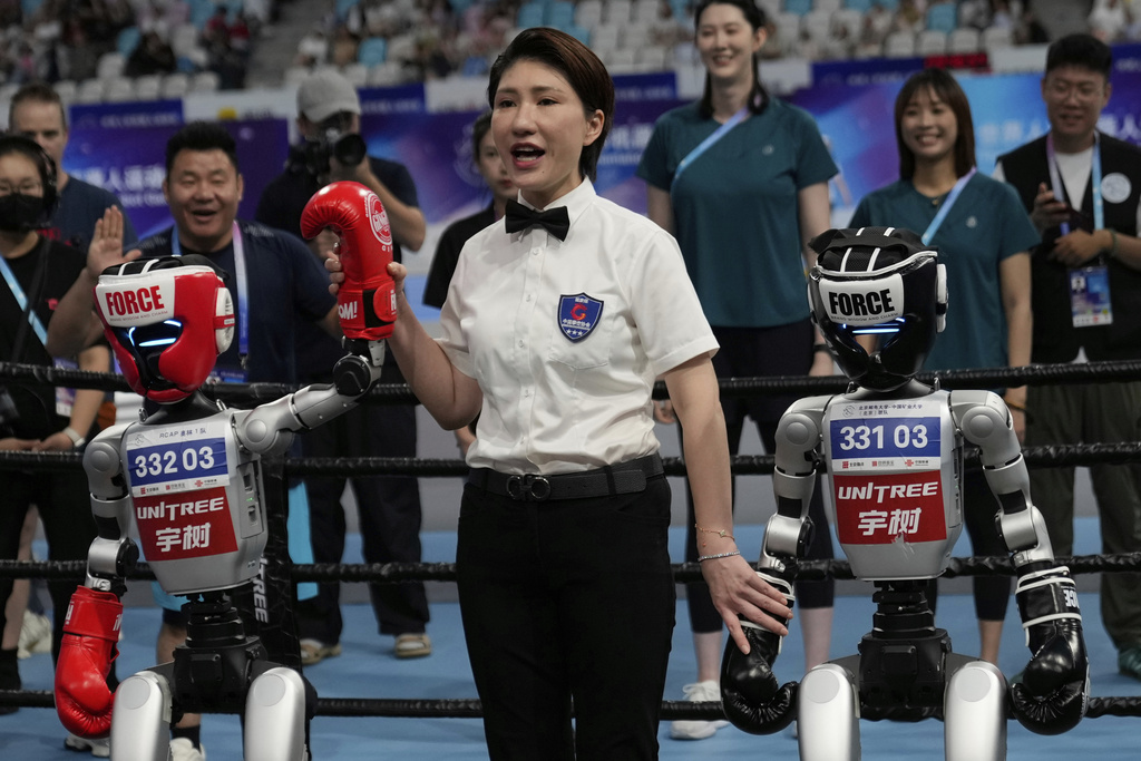 A referee announces the winner of a Free Combat event during the World Humanoid Robot Games held in Beijing, China, Saturday, Aug. 16, 2025. (AP Photo/Mahesh Kumar A.)