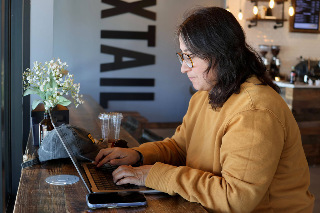 Lauren Contreras, 40, works from her laptop at Foxtail Coffee Co., in Flagstaff, Ariz., on Monday, April 20, 2026. (AP Photo/Cheyanne Mumphrey)
