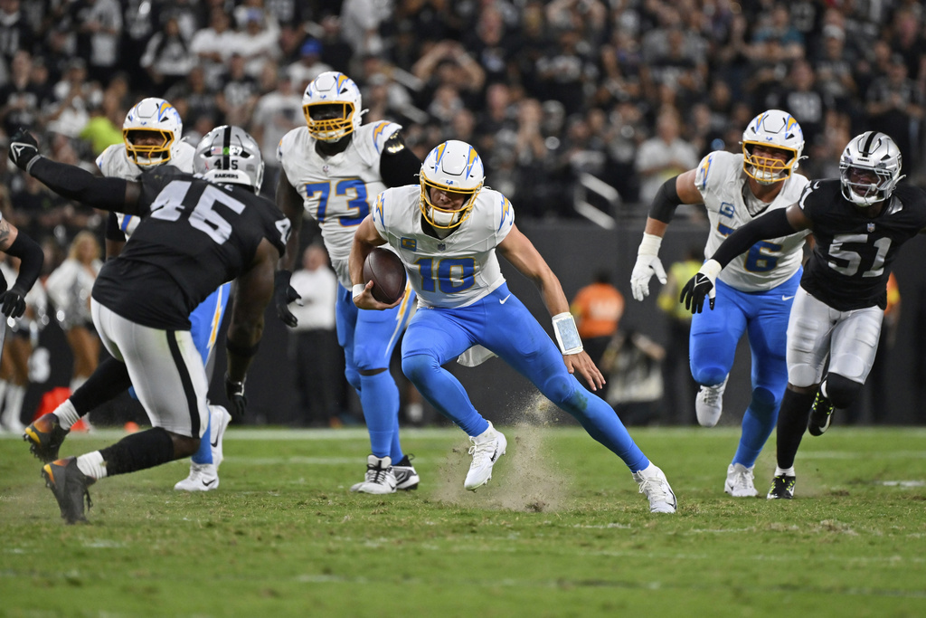 Los Angeles Chargers quarterback Justin Herbert (10) runs with the ball against the Las Vegas Raiders during the first half of an NFL football game, Monday, Sept. 15, 2025, in Las Vegas. (AP Photo/David Becker)
