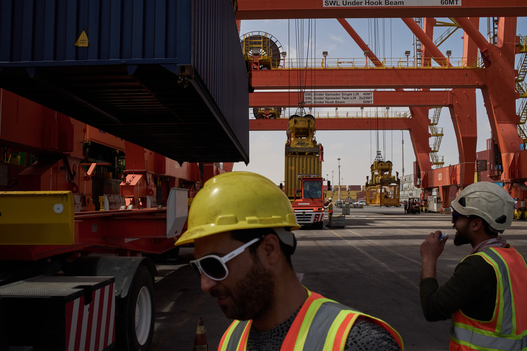 Dockworkers unload cargo containers into trucks at Umm Qasr Port, a deep-water port, in the city of Umm Qasr, Iraq, Friday, March 27, 2026. (AP Photo/Leo Correa)