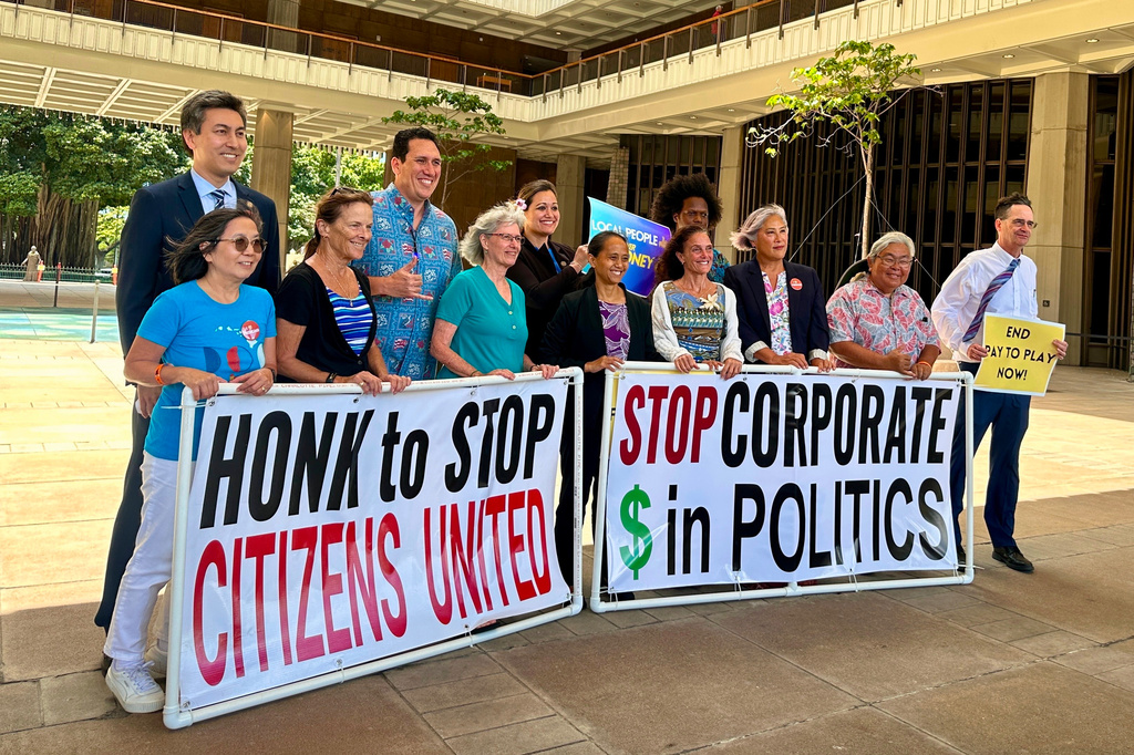 Hawaii lawmakers and activists pose for a photo after discussing a bill that seeks to limit corporate money in politics in Honolulu on Thursday, April 23, 2026. (AP Photo/Jennifer Sinco Kelleher)