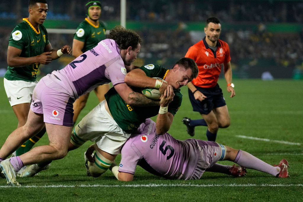 South Africa's Elrigh Louw, center, scores a try as Scotland's Ewan Ashman, left, and teammate Scott Cummings attempt to stop him during the Nations Championship Test rugby match between South Africa and Scotland, in Pretoria, Saturday, July 11, 2026. (AP Photo/Themba Hadebe)