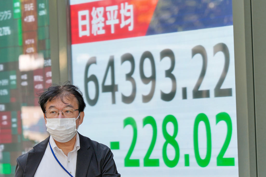 A person walks in front of an electronic stock board showing Japan's Nikkei index at a securities firm Thursday, Oct. 22, 2026, in Tokyo. (AP Photo/Eugene Hoshiko)