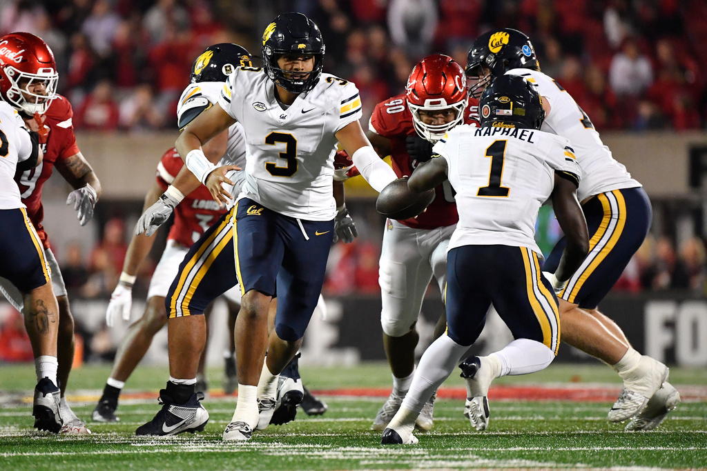 California quarterback Jaron-Keawe Sagapolutele (3) hands off the ball to running back Kendrick Raphael (1) during the second half of an NCAA college football game against Louisville in Louisville, Ky., Saturday, Nov. 8, 2025. (AP Photo/Timothy D. Easley)