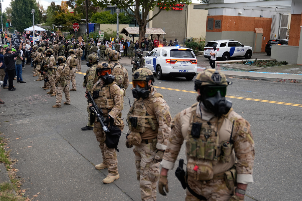 Customs and Border Protection agents stand outside a U.S. Immigration and Customs Enforcement facility during a protest on Saturday, Oct. 4, 2025, in Portland, Ore. (AP Photo/Jenny Kane)