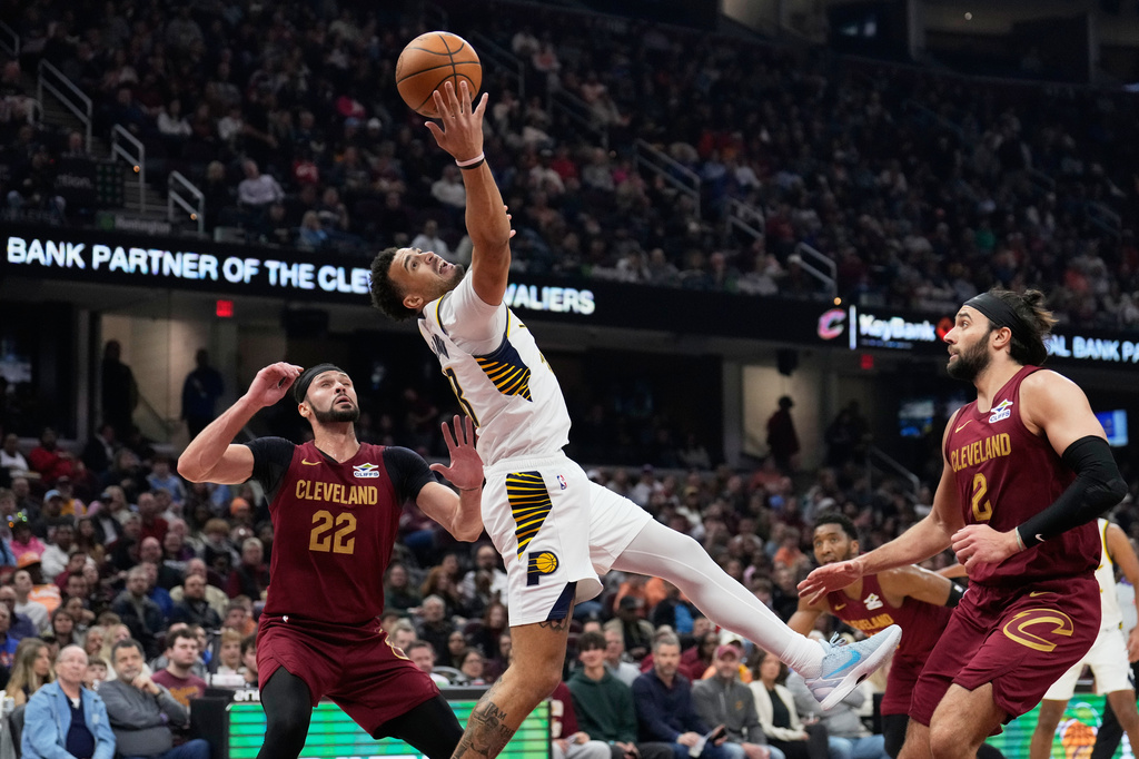 Indiana Pacers forward Jalen Slawson, center, grabs a pass between Cleveland Cavaliers forward Larry Nance Jr. (22) and guard Max Strus, right, in the first half of an NBA basketball game in Cleveland, Sunday, April 5, 2026. (AP Photo/Sue Ogrocki)