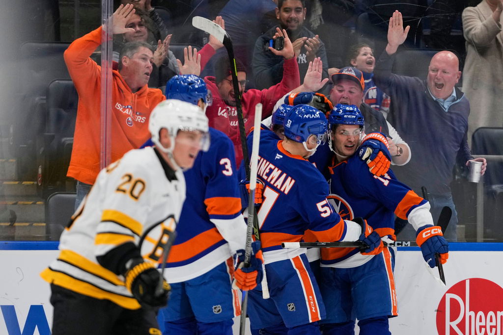 New York Islanders' Bo Horvat, right, celebrates with teammates after scoring a goal as Boston Bruins' Henri Jokiharju, left, looks away during the second period of an NHL hockey game Tuesday, Nov. 4, 2025, at UBS Arena in Elmont, N.Y. (AP Photo/Frank Franklin II)
