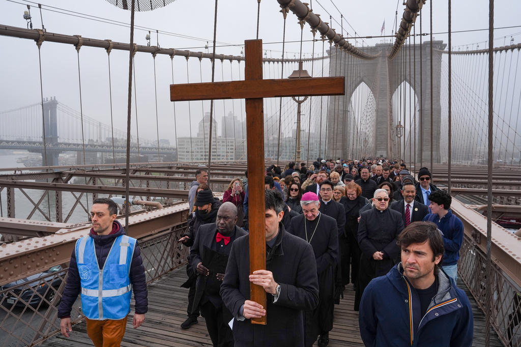A man carries a cross during the "Way of the Cross" over the Brooklyn Bridge on Good Friday, Friday, April 3, 2026, in New York. (AP Photo/Ryan Murphy)