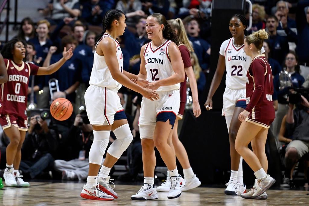 UConn guard Ashlynn Shade (12) reacts toward UConn guard Azzi Fudd in the first half of an exhibition NCAA college basketball game against Boston College, Monday, Oct. 13, 2025, in Uncasville, Conn. (AP Photo/Jessica Hill)