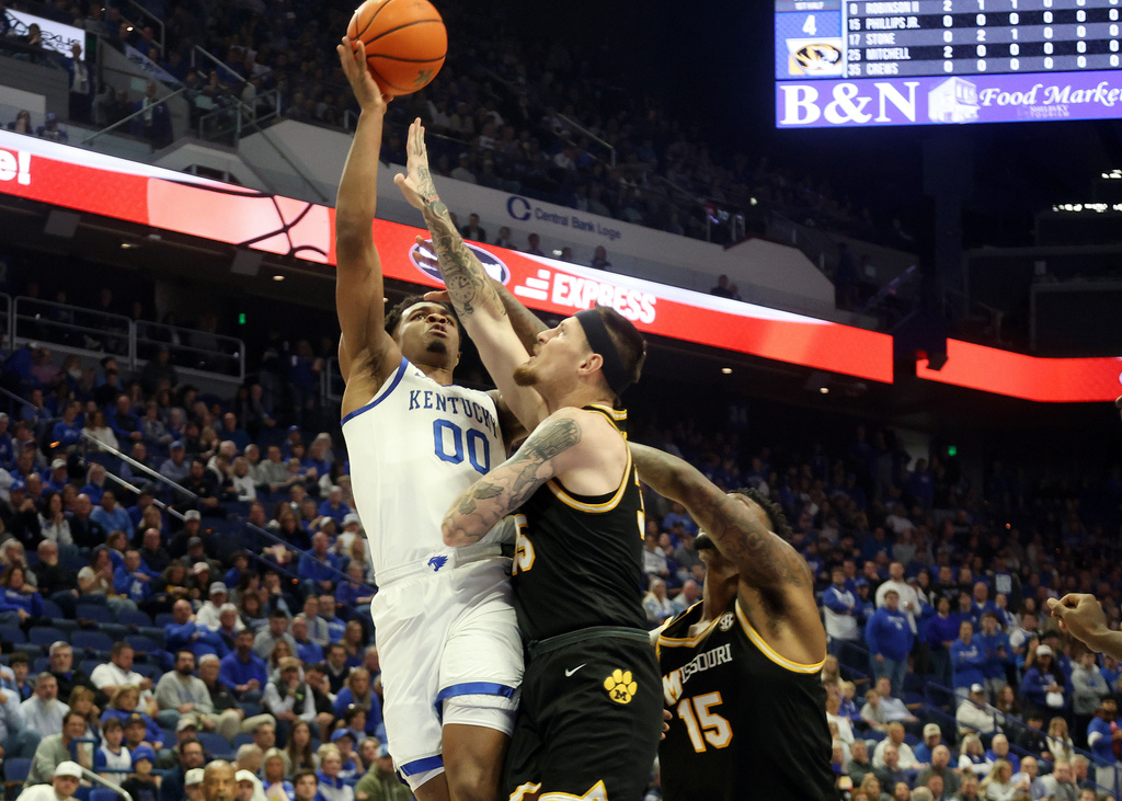 Kentucky's Otega Oweh, left, shoots while defended by Missouri's Jacob Crews, middle and Shawn Phillips Jr. (15) during the first half of an NCAA college basketball game in Lexington, Ky., Wednesday, Jan. 7, 2026. (AP Photo/James Crisp)