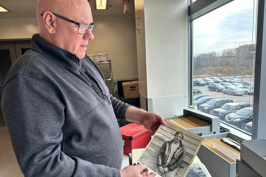 Phil Hallman, a University of Michigan film studies librarian, holds a photo of actor Kevin Costner, Nov. 24, 2025, in Ann Arbor, Mich. (AP Photo/Mike Householder)