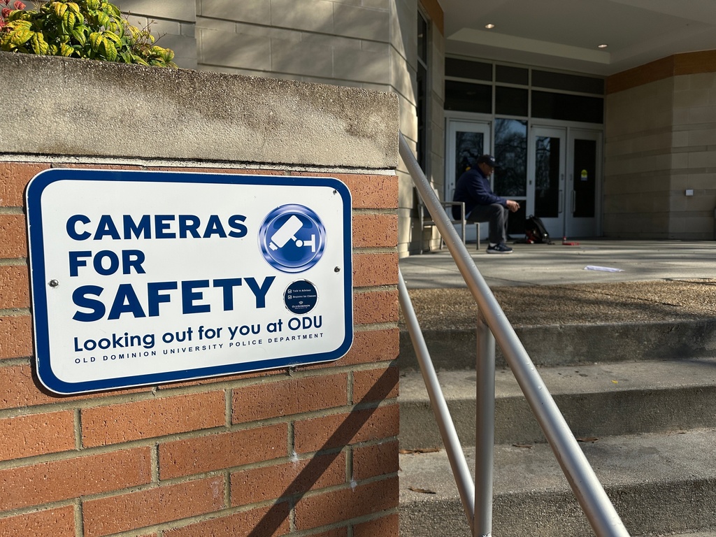 A person sits at the front door of Constant Hall, where yesterday shooting occurred on Friday, March 13, 2026 at Old Dominion Universiy in Norfolk, Va. (AP Photo/Allen G. Breed).