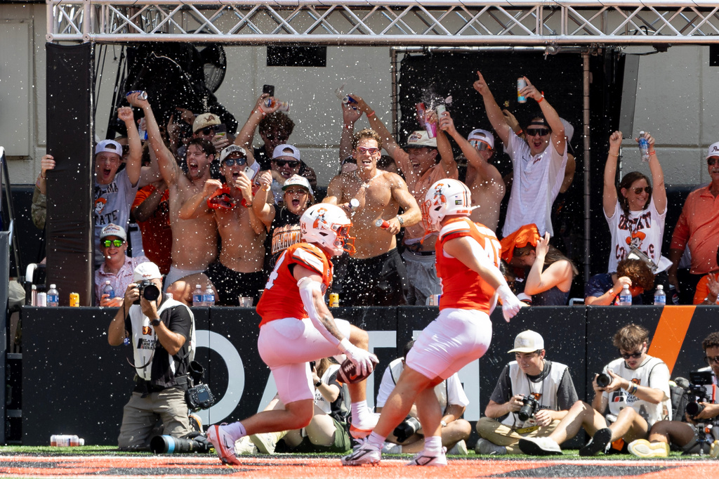 Oklahoma State tight end Carson Kolb (44) celebrates in front of fans with tight end Morgan McPhaul (45) after scoring a touchdown in the first half of the NCAA college football game against Oregon in Stillwater, Okla., Saturday, Sept. 12, 2026. (AP Photo/Mitch Alcala)