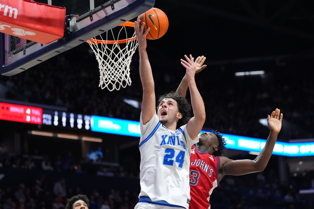 Xavier's Jovan Milicevic scores at the basket as St. John's Joson Sanon defends during the first half of a college basketball game, Saturday, Jan. 24, 2026, in Cincinnati. (AP Photo/Kareem Elgazzar)