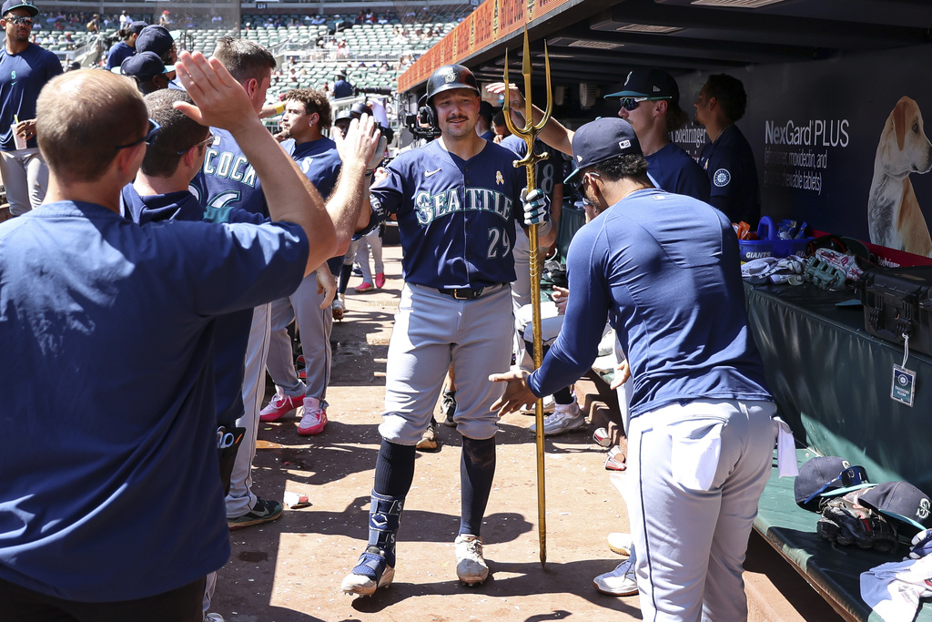 Seattle Mariners' Cal Raleigh (29) celebrates with teammates in the dugout after hitting a three-run home run in the ninth inning of a baseball game against the Atlanta Braves, Sunday, Sept. 7, 2025, in Atlanta. (AP Photo/Colin Hubbard)