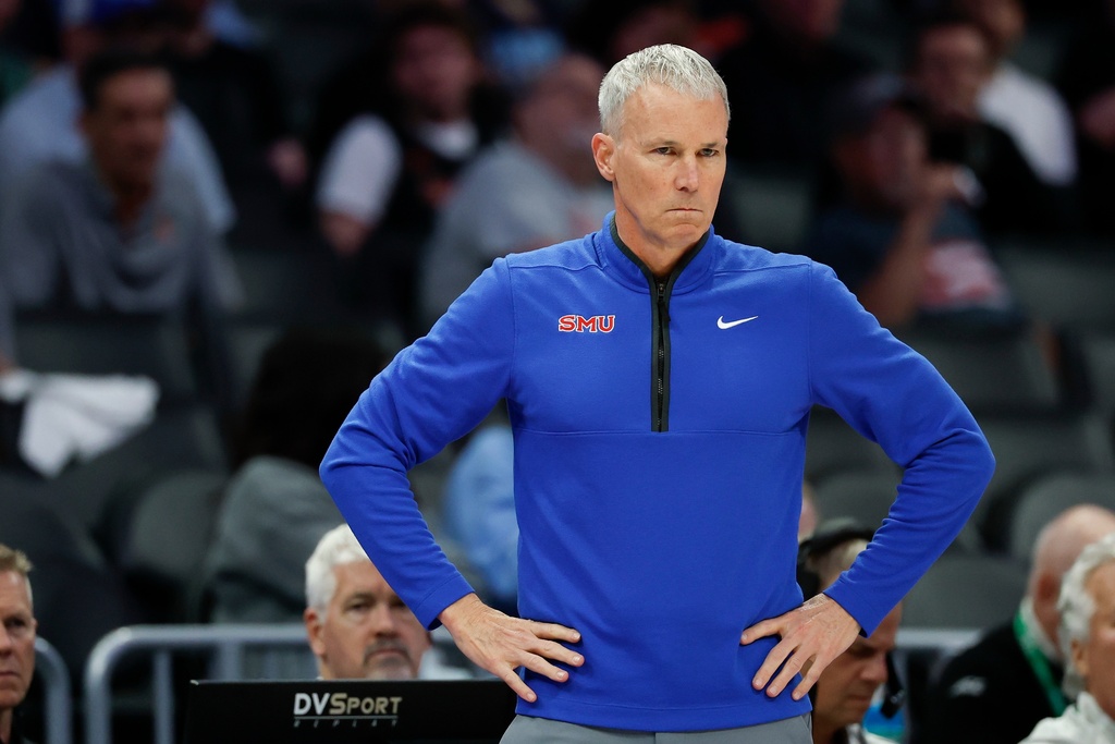 SMU head coach Andy Enfield watches his team play against Louisville during the first half of an NCAA college basketball game in the second round of the Atlantic Coast Conference tournament in Charlotte, N.C., Wednesday, March 11, 2026. (AP Photo/Nell Redmond)