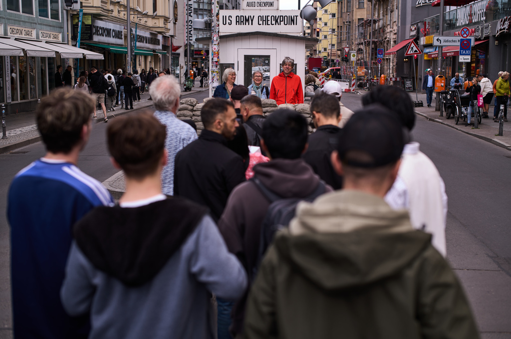 Tourists pose for photos at the reconstructed, former allied Checkpoint Charlie, which marks the border between former East and West Berlin during the Cold War, until the fall of the wall, in Berlin, Germany, Friday, June 12, 2026. (AP Photo/Markus Schreiber)