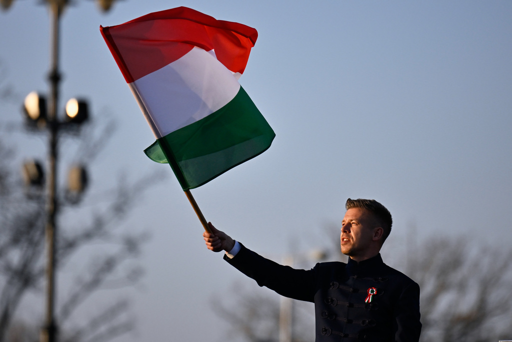 Opposition leader Peter Magyar, center, waves a flag during a march in Budapest, Sunday, March 15, 2026. (AP Photo/Denes Erdos)