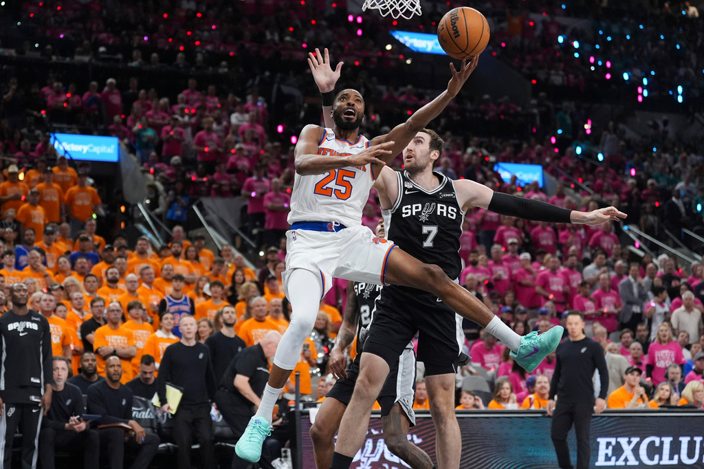 New York Knicks guard Mikal Bridges (25) shoots past San Antonio Spurs center Luke Kornet (7) during the second half of Game 1 of the NBA Finals basketball series, Wednesday, June 3, 2026, in San Antonio. (AP Photo/Eric Gay)