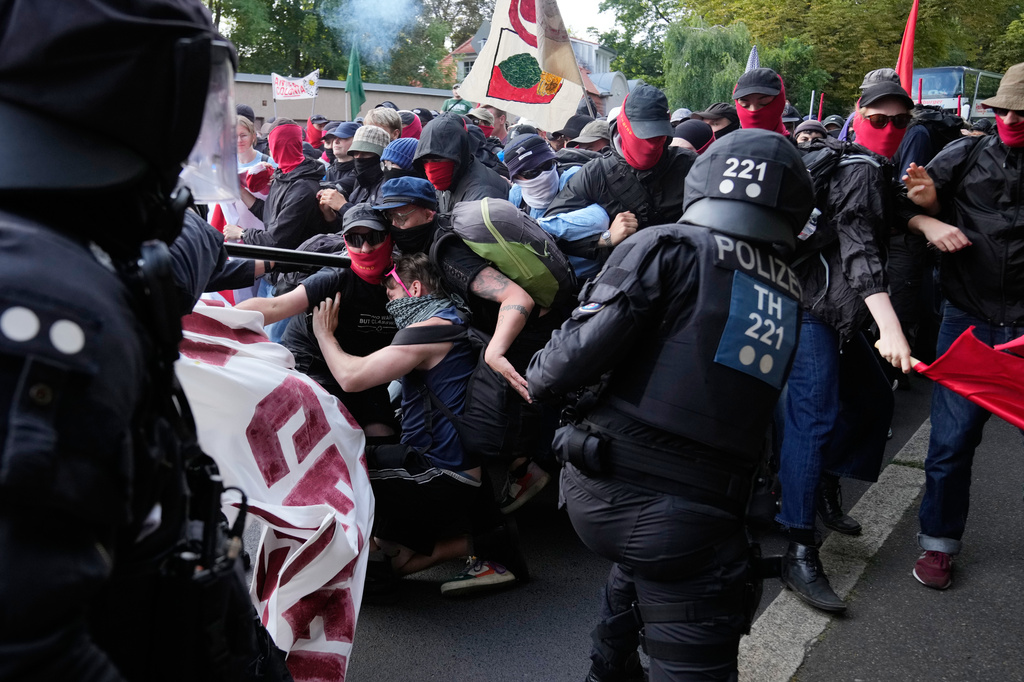 Police officers clash with protesters during a rally against a party convention of Alternative for Germany, or AfD in Erfurt, Germany, Saturday, July 4, 2026. (AP Photo/Ebrahim Noroozi)
