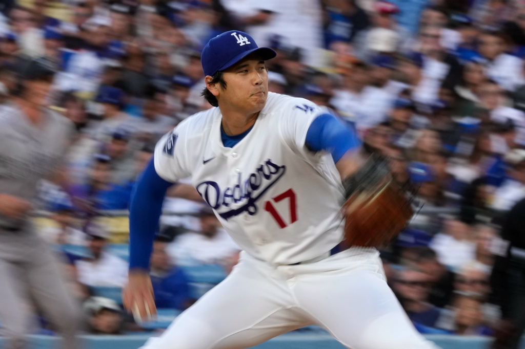 Los Angeles Dodgers pitcher Shohei Ohtani, right, throws to the plate during the first inning of a baseball game against the Colorado Rockies, Wednesday, May 27, 2026, in Los Angeles. (AP Photo/Mark J. Terrill)