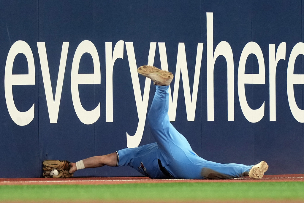 Toronto Blue Jays left fielder Davis Schneider (36) loses the ball as he tries to make a diving catch during the fifth inning of a baseball game against the Colorado Rockies in Toronto, Wednesday, April 1, 2026. (Nathan Denette/The Canadian Press via AP)