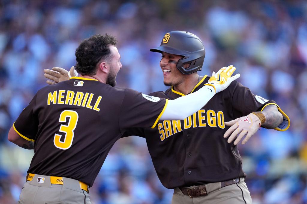San Diego Padres' Manny Machado, right, is congratulated by Jackson Merrill after hitting a three-run home run during the seventh inning of a baseball game against the Los Angeles Dodgers, Sunday, July 5, 2026, in Los Angeles. (AP Photo/Mark J. Terrill)