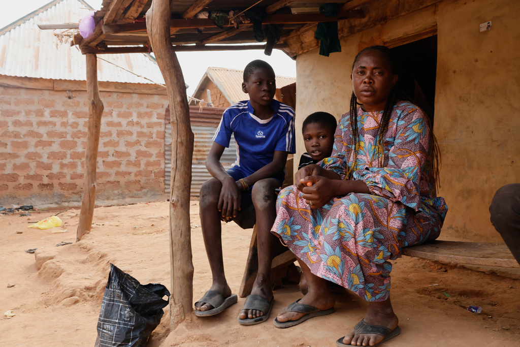 Precious Njikonye, right, the mother of a student at St. Mary's Catholic School, who was abducted by gunmen and later released, sits outside her house in Papiri, Nigeria, Wednesday, Dec. 10, 2025. (AP Photo/Afolabi Sotunde)