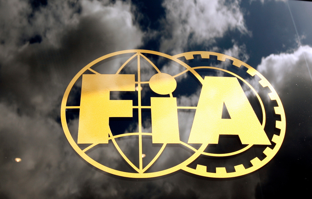 FILE - The FIA logo is seen on glass, with the sky reflected, during a free practice ahead the British Formula One Grand Prix at the Silverstone racetrack, in Silverstone, England, June 19 2009. (AP Photo/Luca Bruno, File)