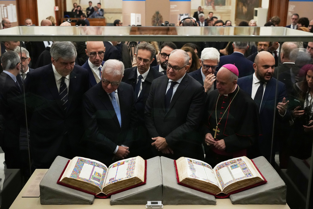 From right, Monsignor Rino Fisichella, Rome's Mayor Roberto Gualtieri and Italian government undersecretary Alfredo Mantovano look at the 15th century Borso D'Este Bible, comprising two illuminated manuscripts, after its unveiling at the Italian Senate as part of the Vatican's Holy Year celebrations in Rome, Thursday, Nov. 13, 2025. (AP Photo/Alessandra Tarantino)