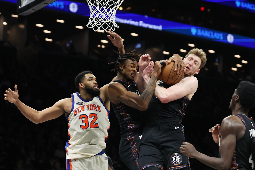 Brooklyn Nets center Nic Claxton, left, and teammate Danny Wolf, right, both go for the rebound during the second half of an NBA basketball game against the New York Knicks, Friday, March 20, 2026, in New York. (AP Photo/Heather Khalifa)