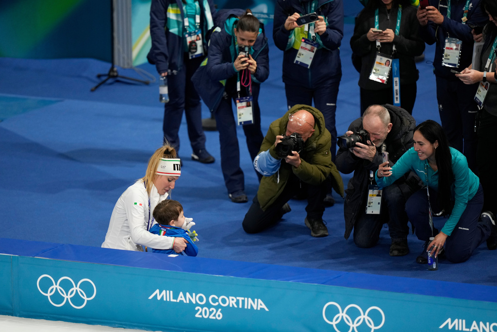 Francesca Lollobrigida of Italy celebrates with her son Tommaso after winning the gold medal in the women's 3,000 meters speedskating race at the 2026 Winter Olympics, in Milan, Italy, Saturday, Feb. 7, 2026. (AP Photo/Luca Bruno)