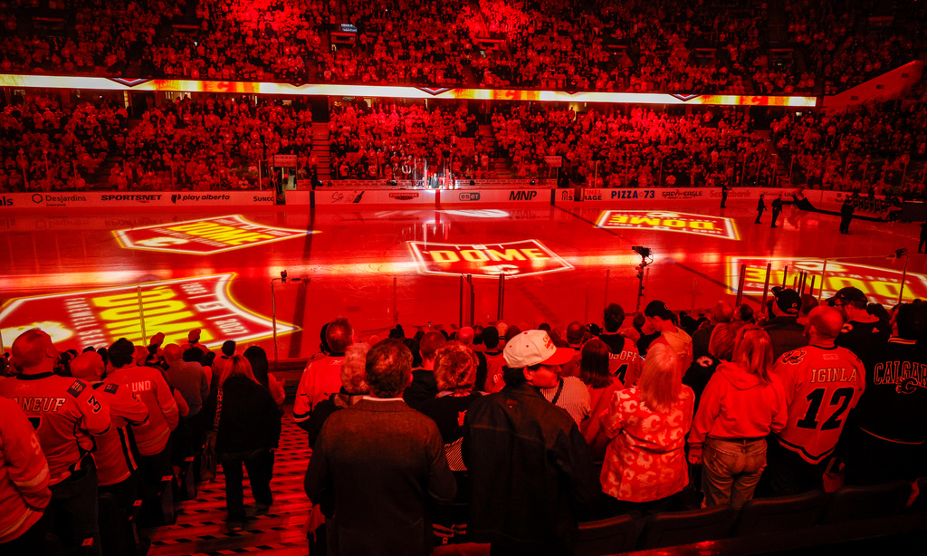 Fans stand as the last season of NHL hockey to be played in the Saddledome gets underway with the Seattle Kraken playing the Calgary Flames in Calgary, Thursday, Oct. 1, 2026. (Jeff McIntosh/The Canadian Press via AP)