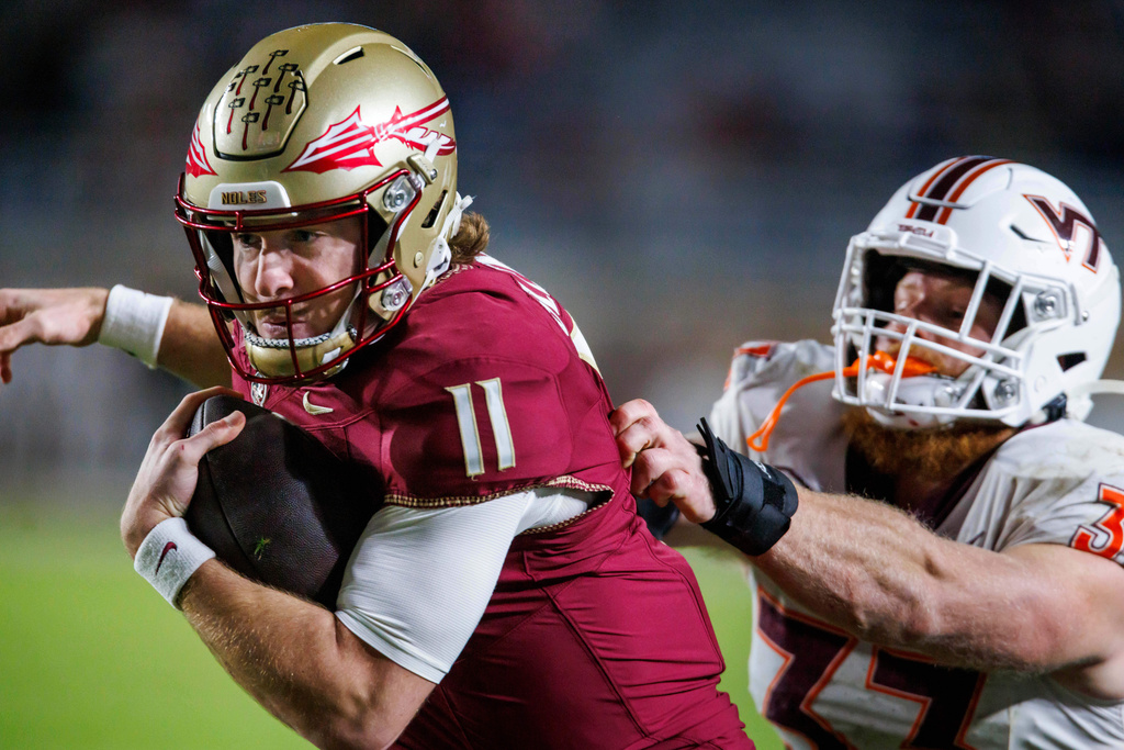 Florida State quarterback Brock Glenn (11) runs away from Virginia Tech defensive lineman Deric Dandy (32) during the second half of an NCAA college football game, Saturday, Nov. 15, 2025, in Tallahassee, Fla. (AP Photo/Colin Hackley)