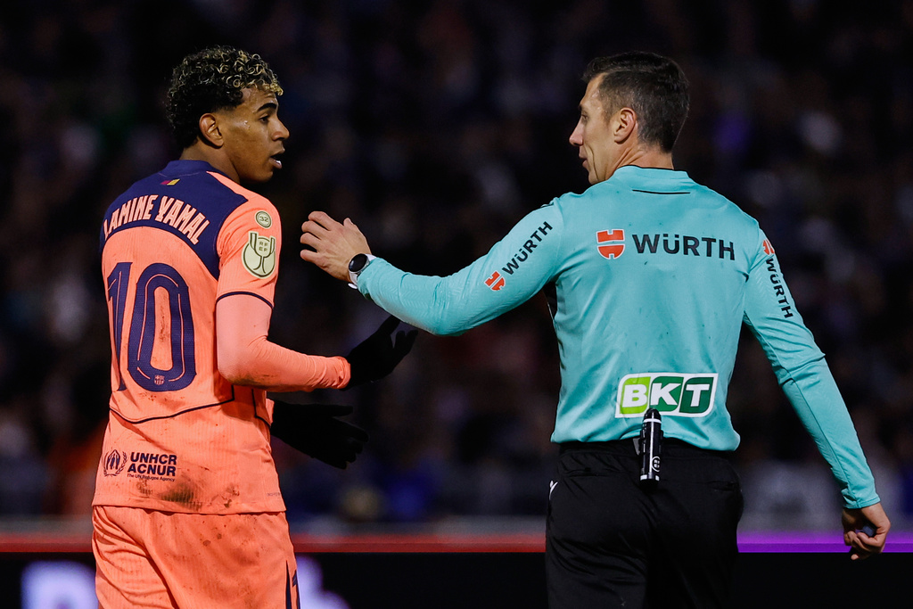 Barcelona's Lamine Yamal, left, talks with the referee during the Copa del Rey soccer match between Guadalajara and Barcelona in Guadalajara, Spain, Tuesday, Dec. 16, 2025. (AP Photo/Rudy Garcia)