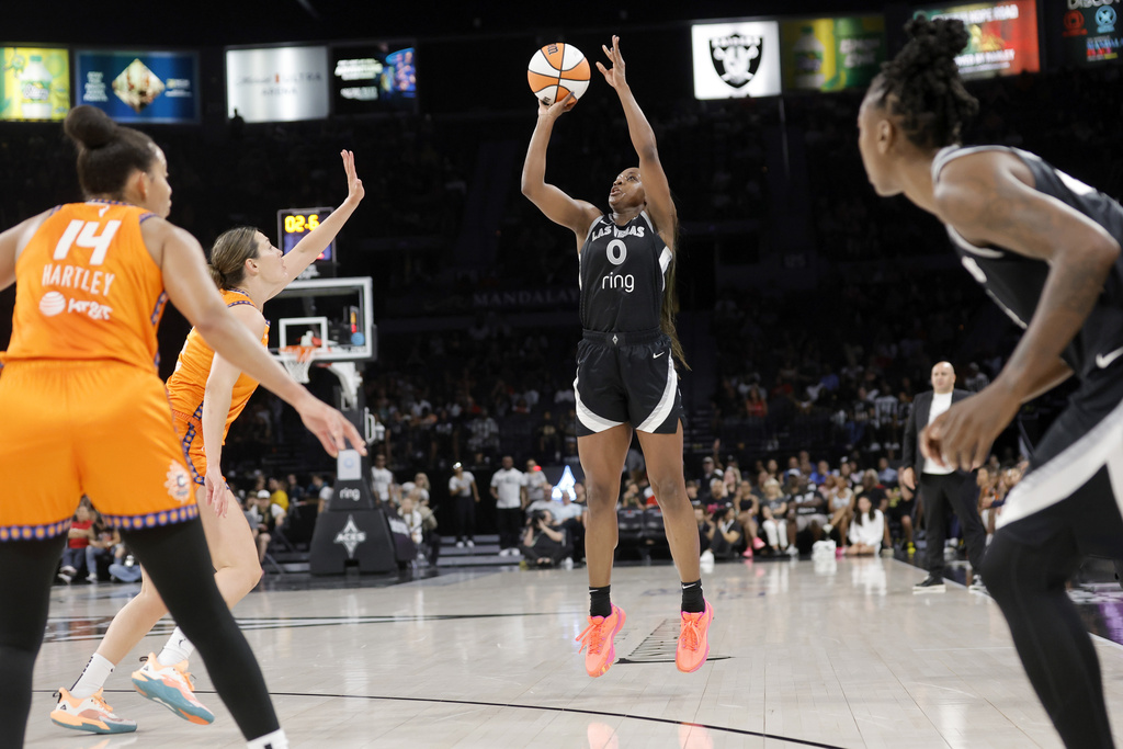 Las Vegas Aces guard Jackie Young (0) goes up to shoot in front of Connecticut Sun guard Bria Hartley (14) and forward Haley Peters, second from left, during the first half of a WNBA basketball game Sunday, Aug. 10, 2025, in Las Vegas. (Steve Marcus/Las Vegas Sun via AP)