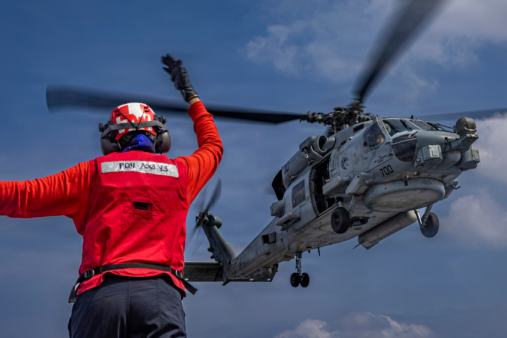 This photo provided by the U.S. Navy shows Aviation Ordnanceman 3rd Class Dianna Hernandez directs an MH-60R Sea Hawk helicopter on the flight deck of the Nimitz-class aircraft carrier USS Abraham Lincoln in the Indian Ocean on Jan. 21, 2026. (Mass Communication Specialist Seaman Daniel Kimmelman/U.S. Navy via AP)
